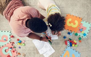 Parent and child engaging in natural environment teaching through play and drawing activities as part of ABA therapy in Maryland