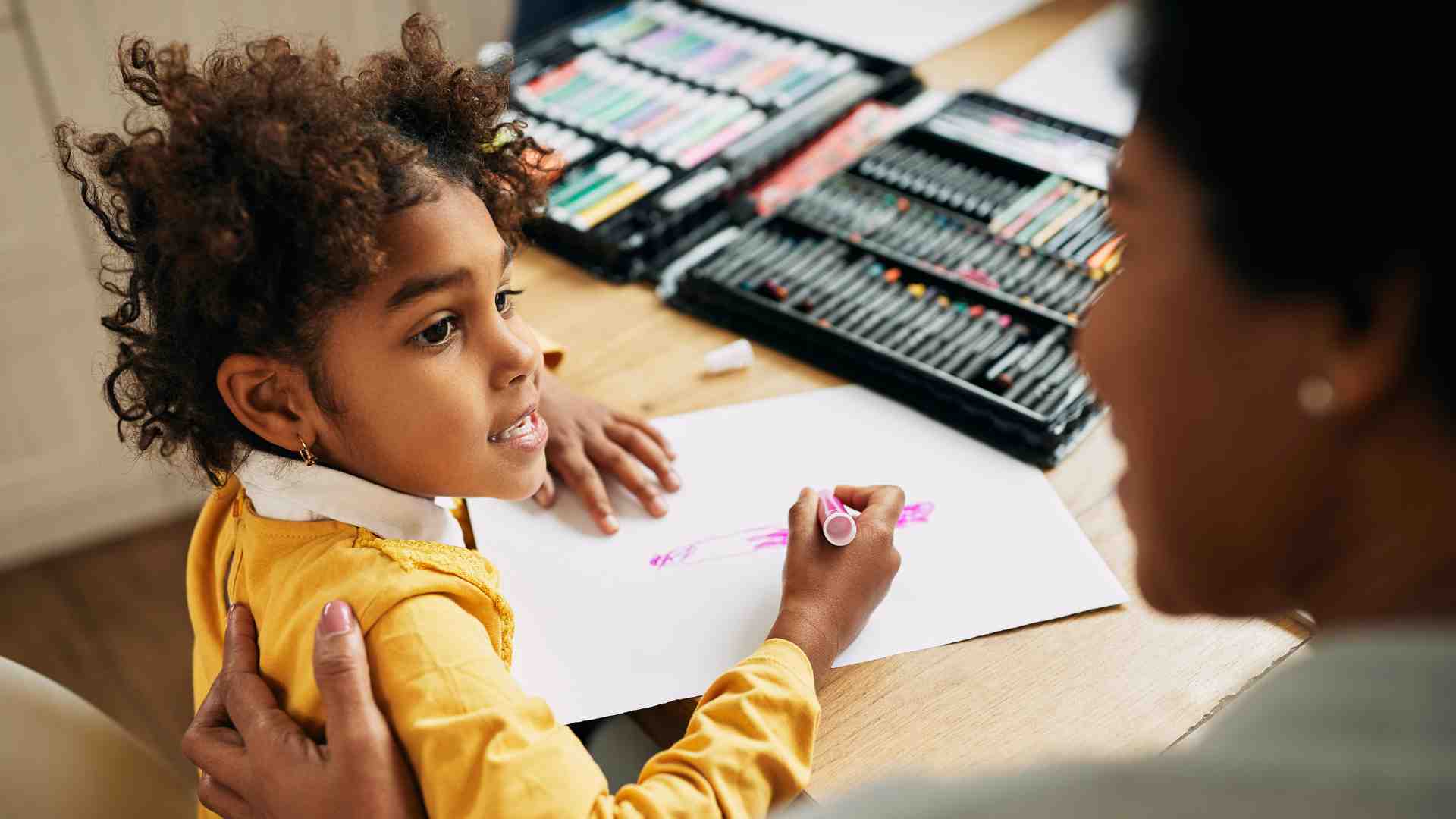 Child drawing during ABA therapy session with behavior analyst support at home in Maryland