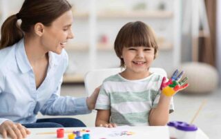 Child smiling during applied behavior analysis Maryland session with therapist at The Learning Tree ABA