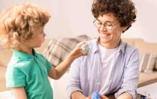 Child engaging in applied behavior analysis near me session with therapist during play-based learning activity