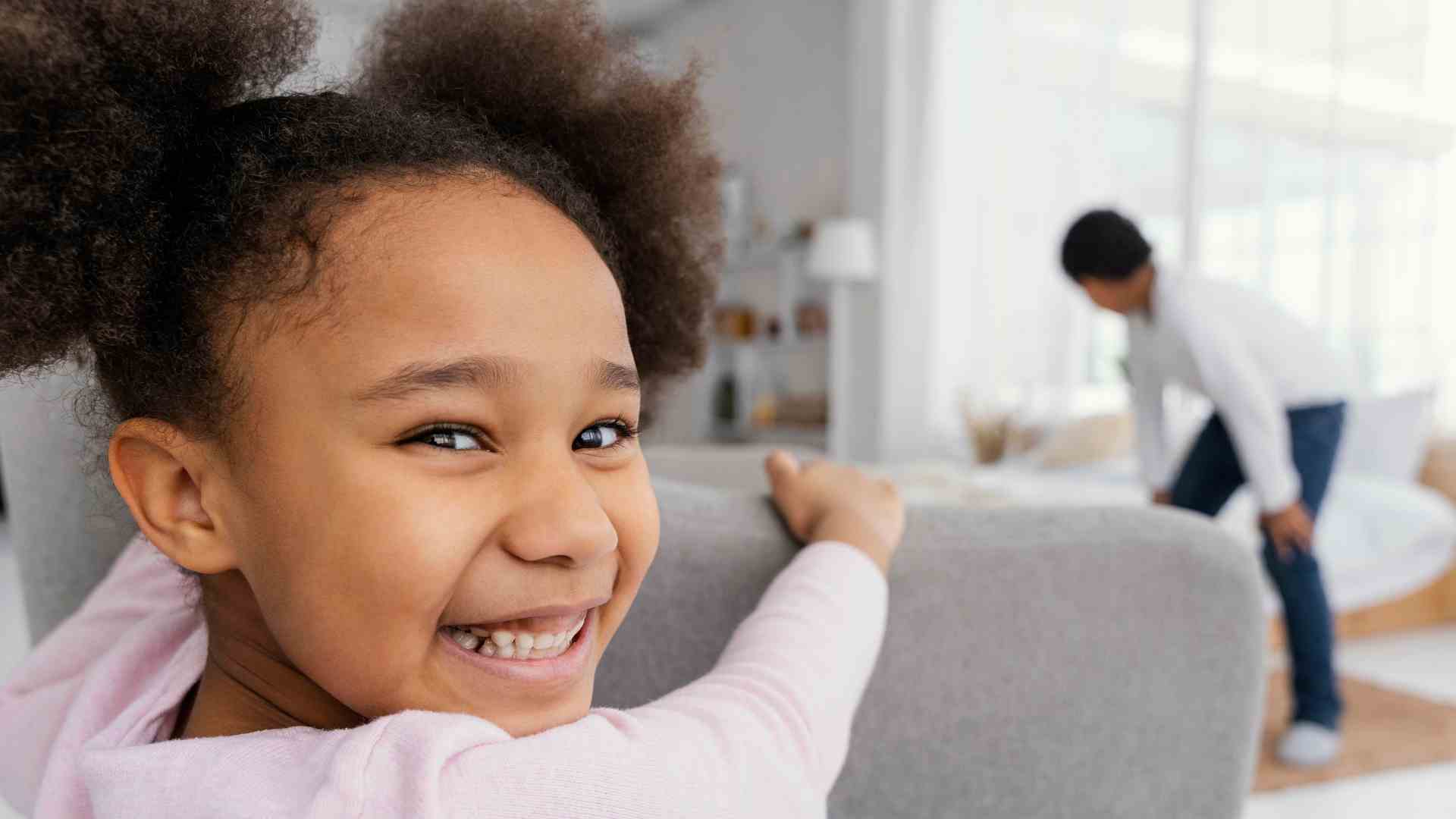Smiling child at home during early childhood intervention near me session with supportive caregiver nearby