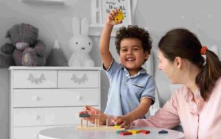 Smiling child practices teaching turn-taking autism through play with an adult using colorful wooden blocks.