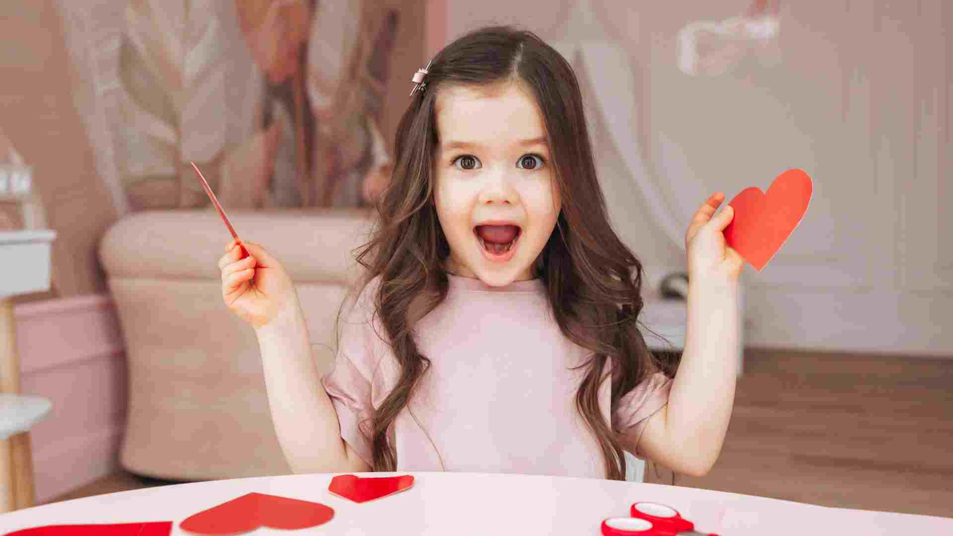 oung girl with autism joyfully making Valentine's Day paper hearts at home, preparing for classroom card exchange