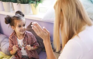 Child engaging with ABA therapist using play-based techniques and positive reinforcement during autism therapy session
