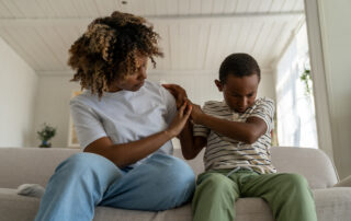 Child with autism showing signs of anxiety and withdrawal at home while a caring adult offers support, illustrating how anxiety and autism co-occur and how ABA therapy helps Maryland families