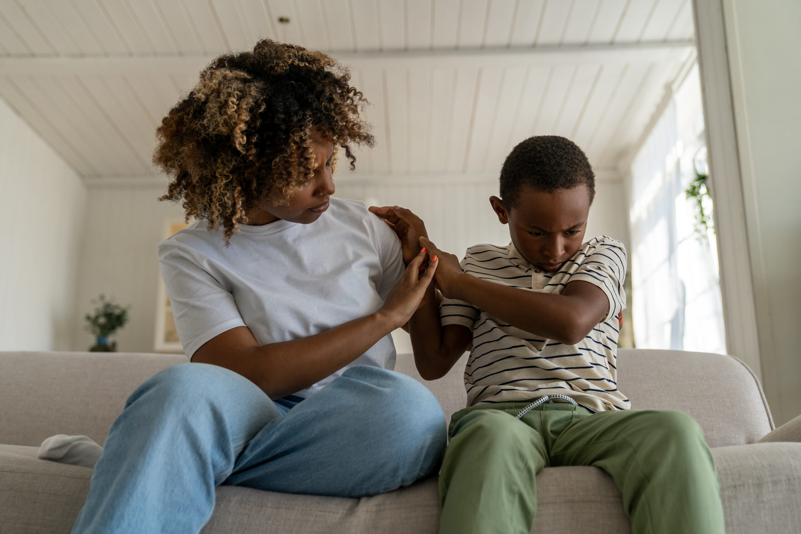 Child with autism showing signs of anxiety and withdrawal at home while a caring adult offers support, illustrating how anxiety and autism co-occur and how ABA therapy helps Maryland families