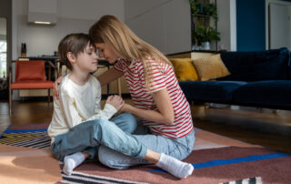 Mother co-regulating with her child with autism on the floor at home, supporting emotional regulation through calm connection