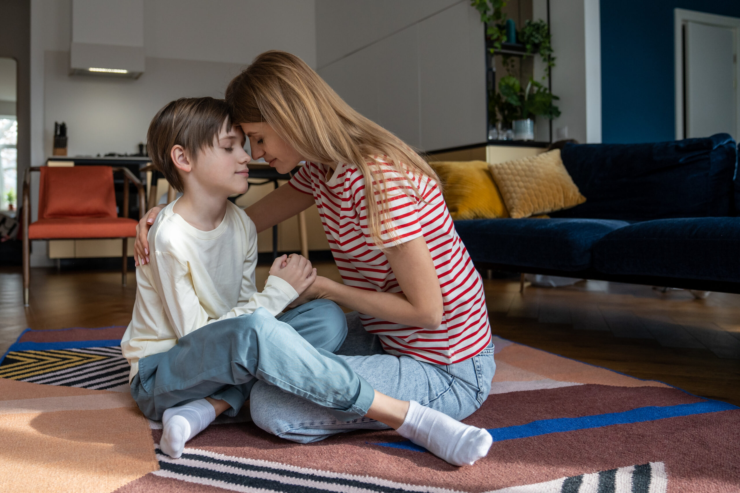 Mother co-regulating with her child with autism on the floor at home, supporting emotional regulation through calm connection