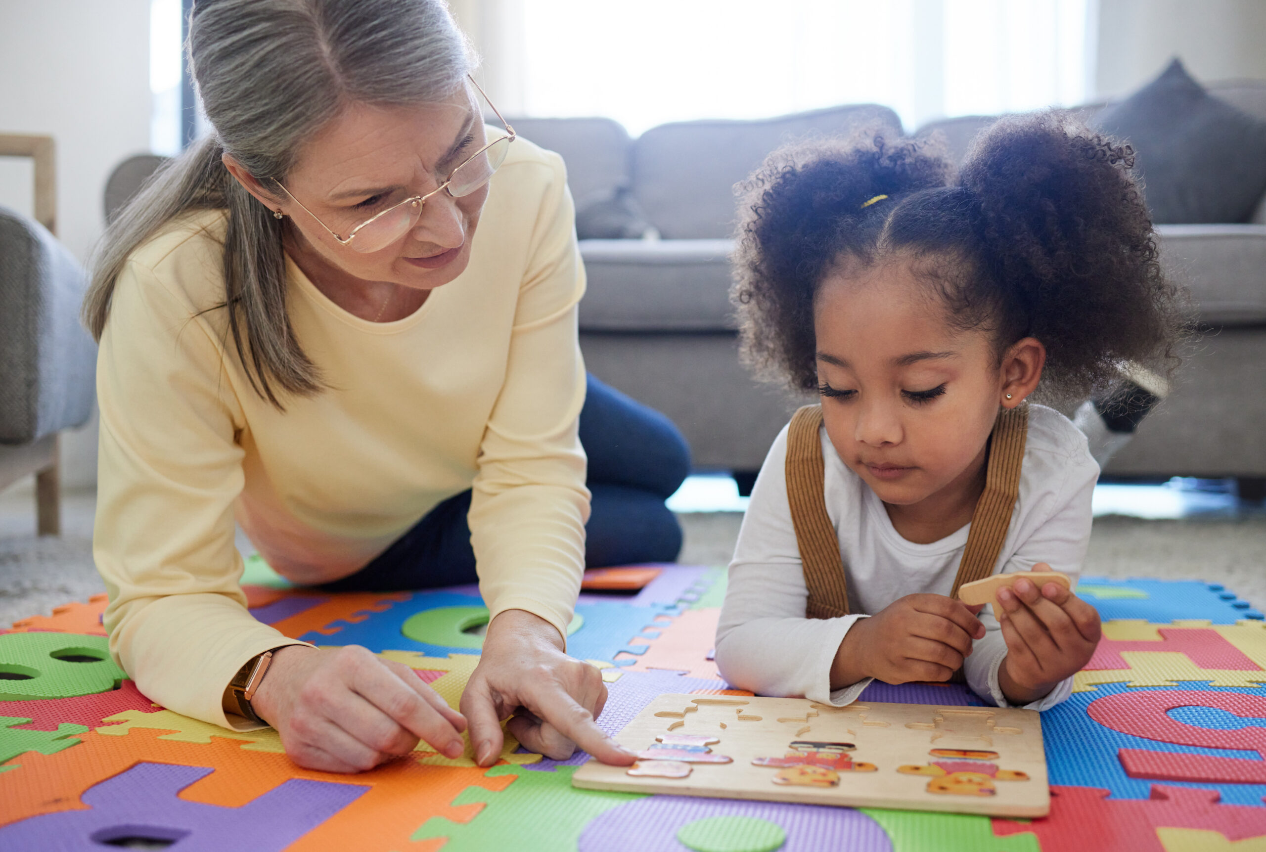 Behavior technician working one-on-one with a young child on a puzzle during an ABA therapy session at home in Maryland, illustrating the play-based approach used at The Learning Tree ABA
